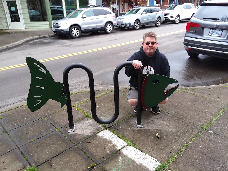 Green salmon bike rack in front of Frenzi.
