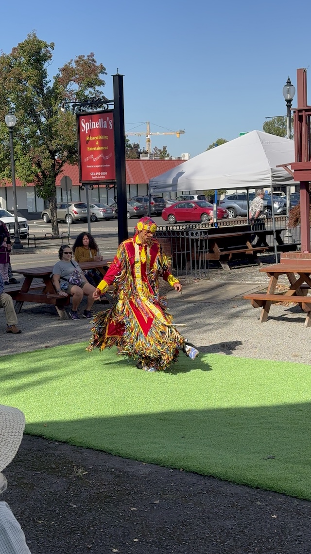 A Native dancer in red regalia performing.