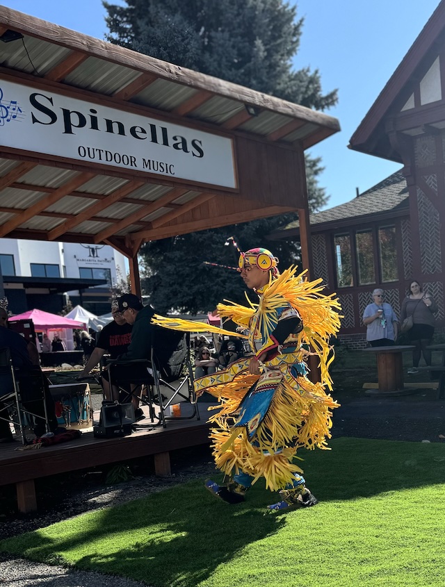 Native dancer in regalia outside.