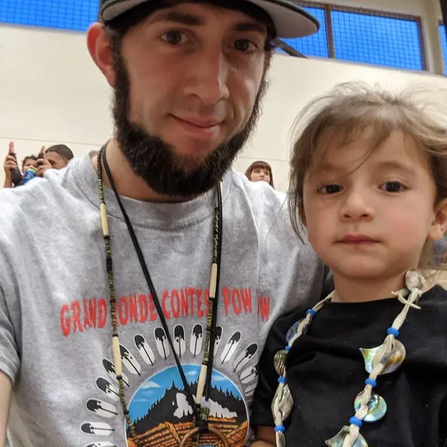 Man and girl smiling at the camera.