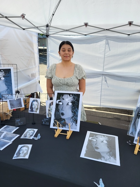 Photo of woman standing in artist booth.