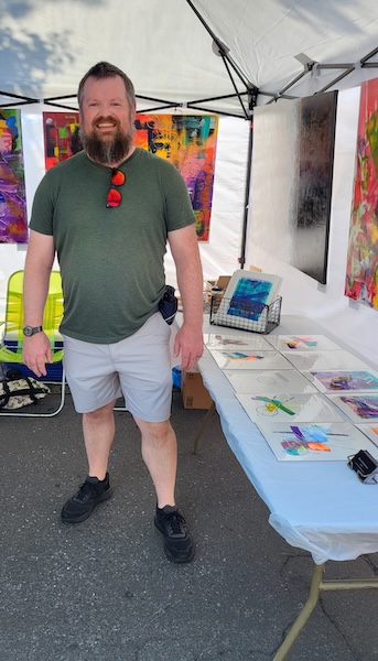 Photo of man standing in artist booth.